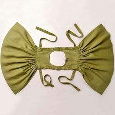 a green bow tie on top of a white surface with a pair of scissors next to it