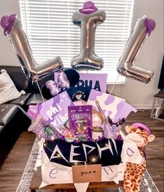 a birthday gift basket with balloons and gifts in the shape of an i love you sign