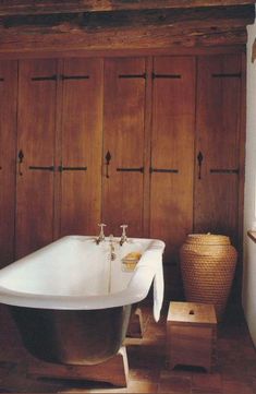 an old fashioned claw foot bathtub in a bathroom with wood paneled walls and flooring