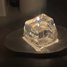 a lit candle sitting on top of a metal plate