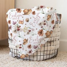 there is a blanket on the floor in front of a basket with flowers and leaves