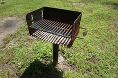 a grill sitting on top of a grass covered field