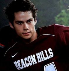 a young man wearing a maroon jersey with the words beacon hills on it's chest