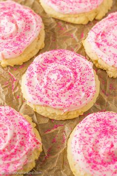 pink sprinkles on top of white frosted cookies