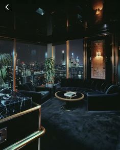 a living room filled with black furniture and tall buildings