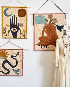 two wall hangings with hand and foot prints on them, one is made from fabric