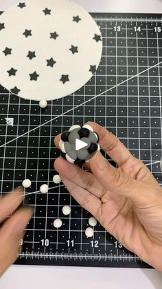 someone is cutting out stars and circles on a piece of black paper with white dots