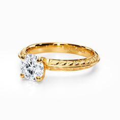 a yellow gold engagement ring with a round diamond in the center and braided band