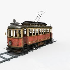 an old red trolley car sitting on top of a metal rail road track with no passengers