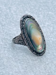 Sterling abalone blister pearl vintage silver ring Ring size 7 1/2 Signed Sterling  Ornate design on the sterling Good condition See pictures for additional details Vintage Iridescent Rings For Wedding, Vintage Silver Oval Pearl Ring, Antique Silver Oval Pearl Ring, Vintage Silver Oval Opal Ring, Vintage Hallmarked Pearl Ring, Vintage Silver Opal Ring With Oval Shape, Handmade Vintage Oval Pearl Ring, Vintage Silver Opal Cabochon Ring, Antique Silver Pearl Ring