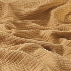 the texture of an unmade bedspread is shown in close up, as if it was made from natural material