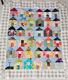 a quilt made to look like houses on a checkered table cloth