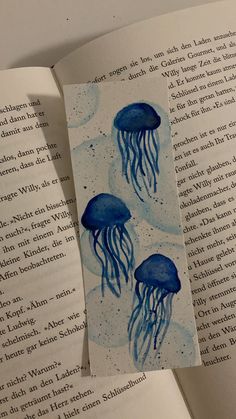 an open book with two blue jellyfish on it