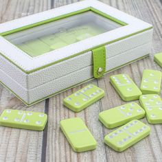 green and white dices sitting on top of a wooden table next to a box