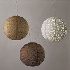 three hanging lights made out of woven paper and wood, each with an intricate design