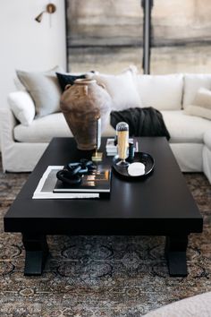 a living room filled with white couches and a black coffee table