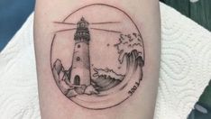 a small lighthouse tattoo on the arm