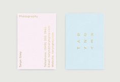 two business cards with gold foil lettering on the front and back, one in light blue and pink