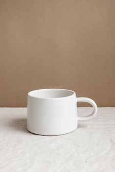 a white cup sitting on top of a table