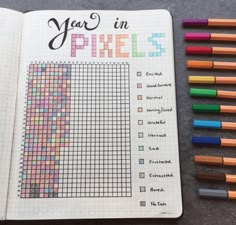 an open notebook with colored pencils next to it and the words year in pixels