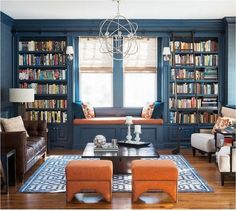 an image of a living room with blue walls and bookshelves in the background