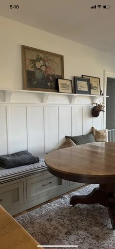 a table and bench in a room with white paneling