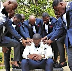 a group of men in suits and ties are huddled together