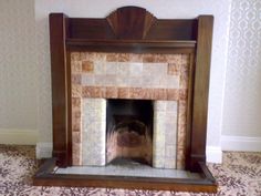 an old fireplace in a room with tile flooring and wall paper on the walls