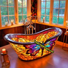 a bathtub that has a butterfly stained glass design on the side and sides, in front of two windows