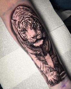 a black and white tiger tattoo on the arm