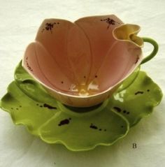 a pink flower sitting on top of a green plate