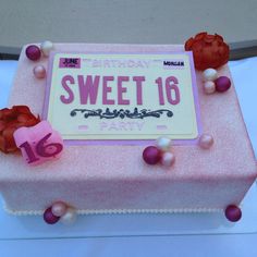 a birthday cake with pink frosting and pearls on it's side, decorated with the number sixteen