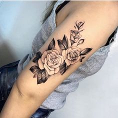 a black and white rose tattoo on the arm