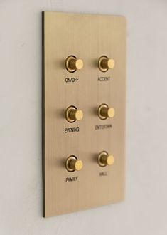 a light switch with four different knobs mounted on the side of a white wall