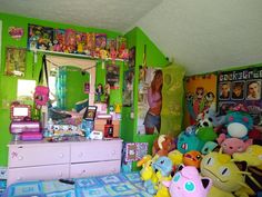 a room filled with lots of stuffed animals on top of a blue and green bed