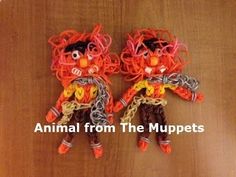 two orange and black cats made out of yarn sitting on top of a wooden table