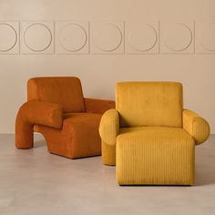 two orange chairs sitting next to each other in a room with circles on the wall