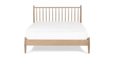 a bed with white sheets and wooden headboard on it's side, against a white background