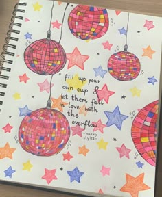 a spiral notebook with some colorful ornaments hanging from it's sides and the words, fill up your own cup or let them fall in love with the overflow