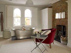 a bath tub sitting next to a fire place in a living room filled with furniture