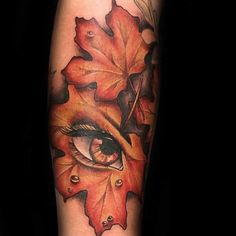 a woman's arm with leaves and an eye on it