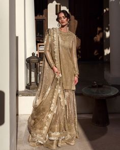 Gold Sharara With Sheer Dupatta In Raw Silk, Gold Raw Silk Sharara With Sheer Dupatta, Eid Reception Traditional Wear With Sequins, Gold Anarkali Kurta With Sheer Dupatta, Festive Elegant Sherwani With Sheer Dupatta, Gold Anarkali Kurta For Reception, Gold Tissue Silk Sharara For Eid, Gold Sharara With Resham Embroidery For Diwali, Elegant Semi-stitched Sherwani With Sheer Dupatta