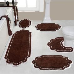 bathroom rugs in brown and white colors on the floor next to a bathtub