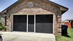 a brick house with two garage doors and windows