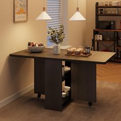 a dining room table with food on it and two lamps hanging over the table in front of them