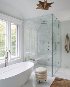 a bathroom with a large glass shower and white bathtub