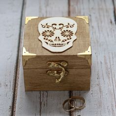 a wooden box with a skull on the lid and keychain attached to it