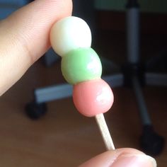 a person is holding two candy lollipops on a stick in their hand