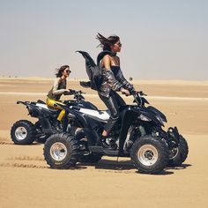 two women riding four wheelers in the desert