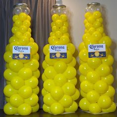 three large yellow balloons are on display in front of the wall and behind each other